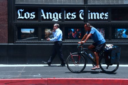 People make their way past the Los Angeles Times office building in downtown Los Angeles, California on July 16, 2018. (Photo by Frederic J. BROWN / AFP)