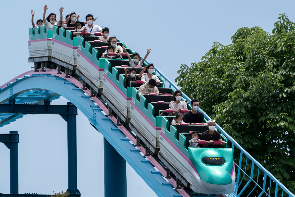 Visitors wearing face masks ride a roller coaster at the Tochinoki Family Land amusement park on May 17, 2020 in Utsunomiya, Tochigi, Japan