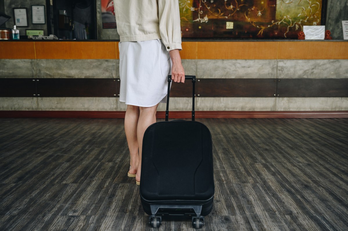 woman rolling a suitcase in a hotel lobby