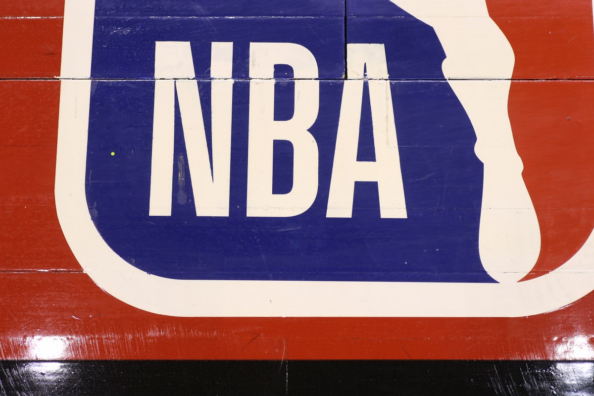 A detailed view of the NBA logo painted on the wooden floor boards of the court