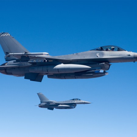 Two F-16 fighter aircraft flying in formation.