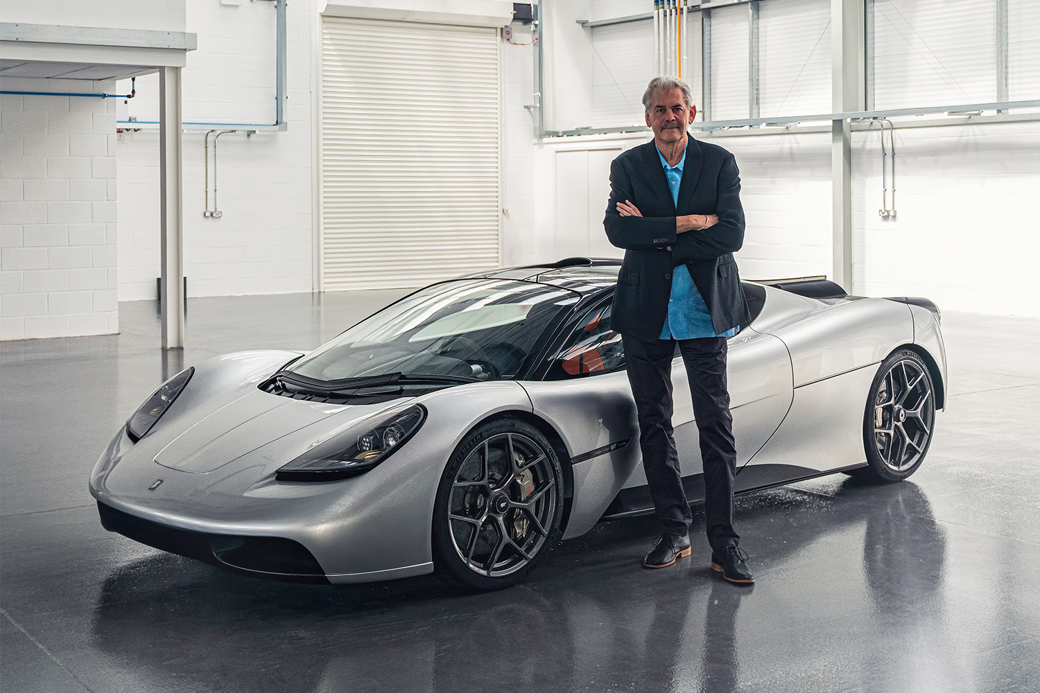 Gordon Murray standing next to his new supercar the T.50