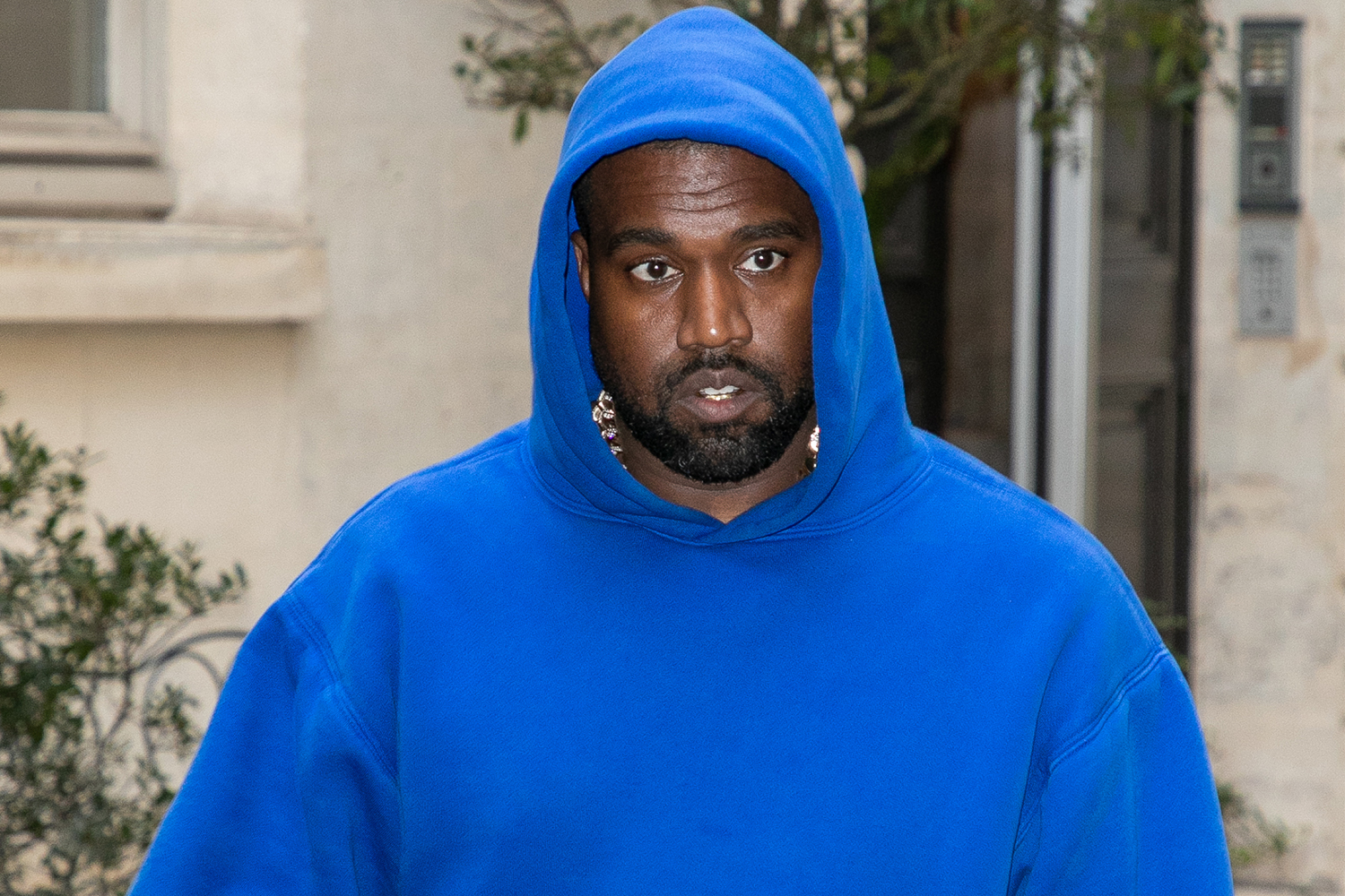 Kanye West wears a blue hoodie while photographed in Paris, France