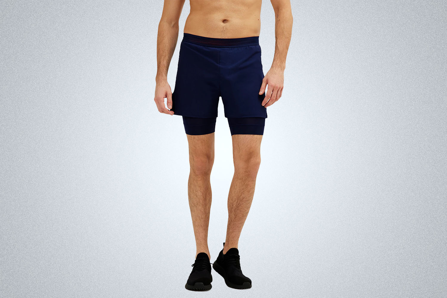 a model in a pair of Rhone Swift Shorts on a grey background