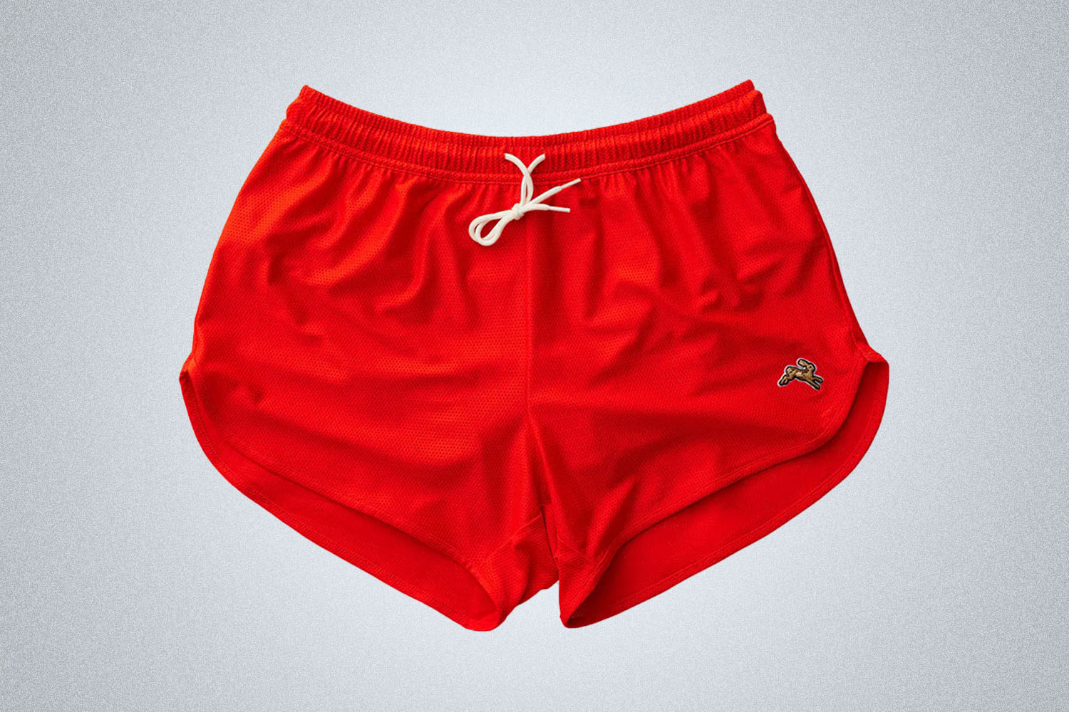 a pair of red Tracksmith shorts on a grey background