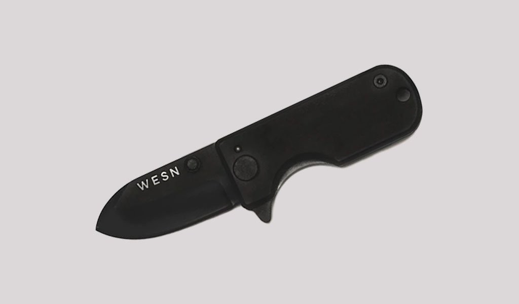 an all black WESN Microblade knife on a grey background