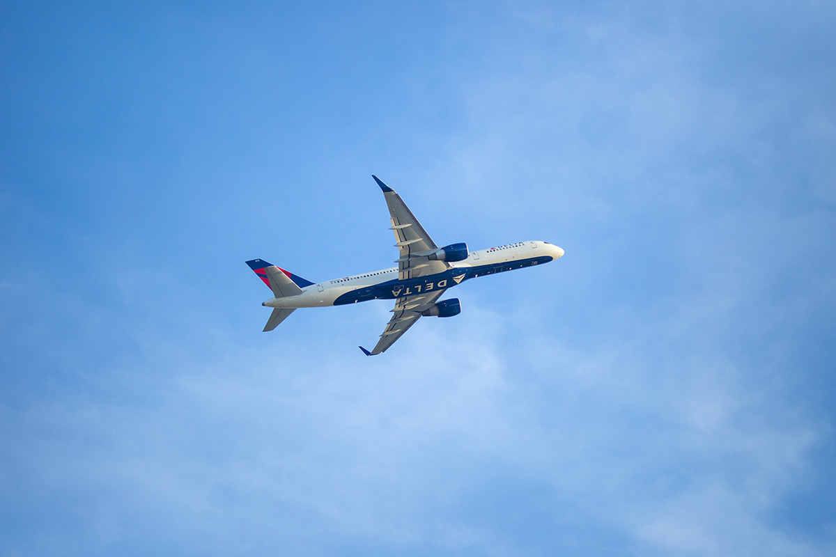 Delta airplane flying against a blue sky