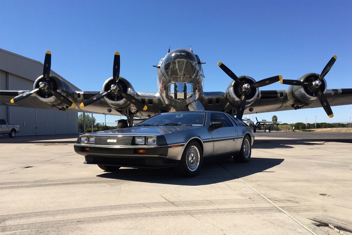 DeLorean DMC-12 stainless steel car in front of an airplane