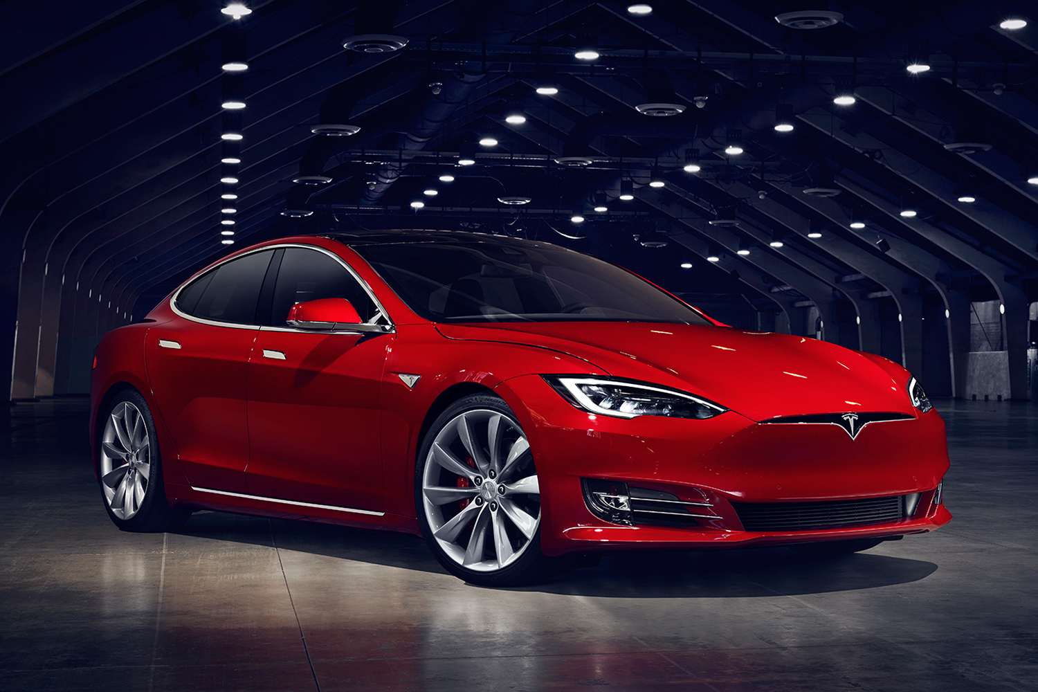 Red Tesla Model S electric sedan in a hangar