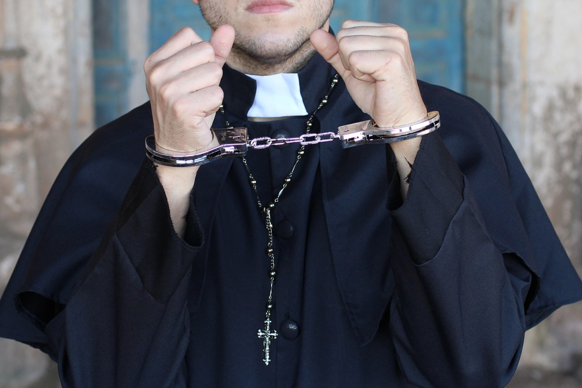 priest wearing handcuffs