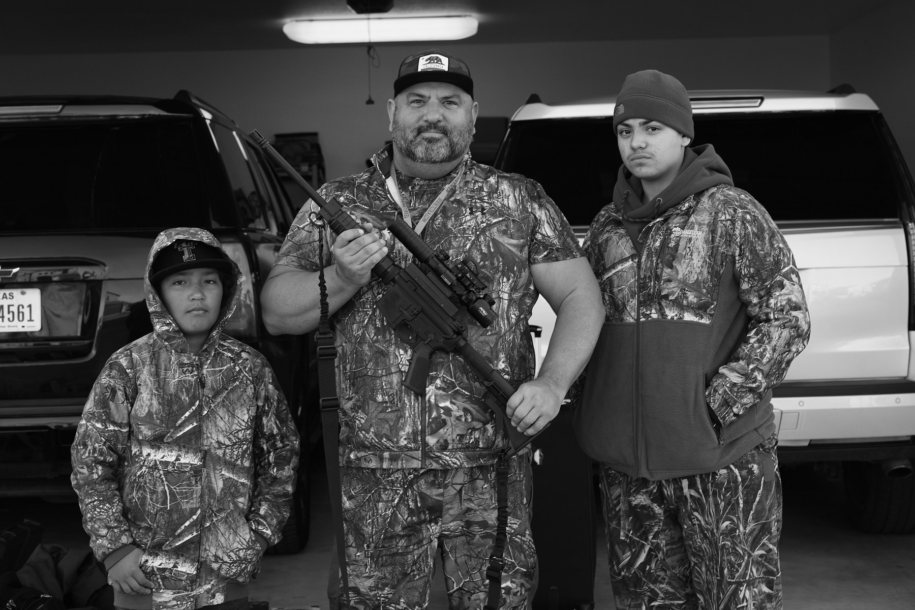 Brian Chavez (center) with his MP15, is flanked by his nine-year-old godson and nephew, Fernando Chavez (left), and his 15-year-old stepson, Kade Ramos (right). <br><br>“I went out to see Brian and he was getting ready to go out hunting,” Clark says. “He went to Harvard and then University of Texas Law School and he's a super smart guy. I would say he's probably a good Democrat, but he's out there in the part of the world where, Democrat or not, you go hunting.”