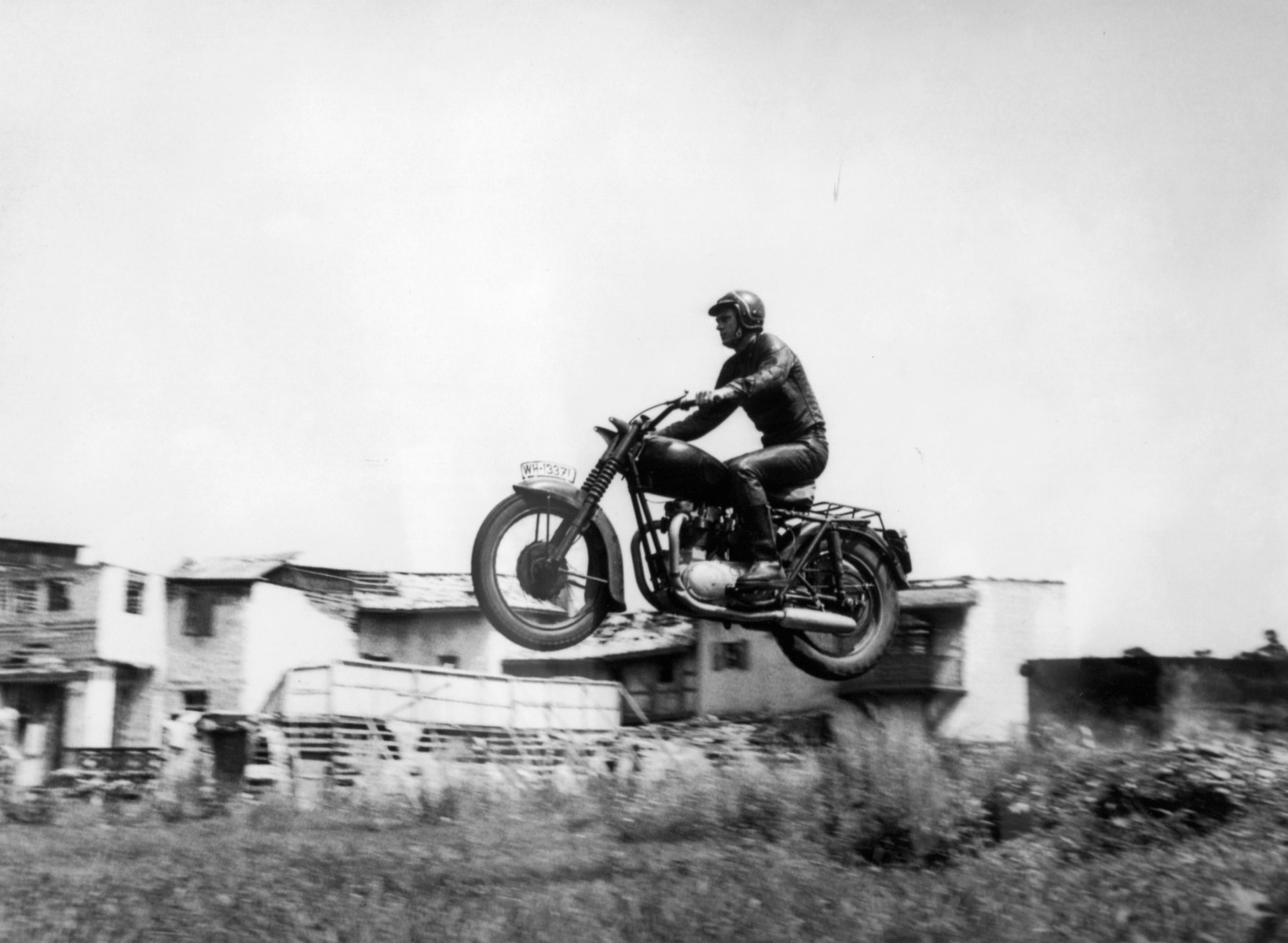 "This is McQueen getting airborne on a motorcycle in between takes on <em>The Great Escape</em>, the 1963 movie that minted him a worldwide superstar,” Terrill says. “McQueen didn’t perform the famed jump over the barbed-wire fence at the end of the film — that was Bud Ekins — but many said he had the skills to do so, as evidenced in this photo.”
