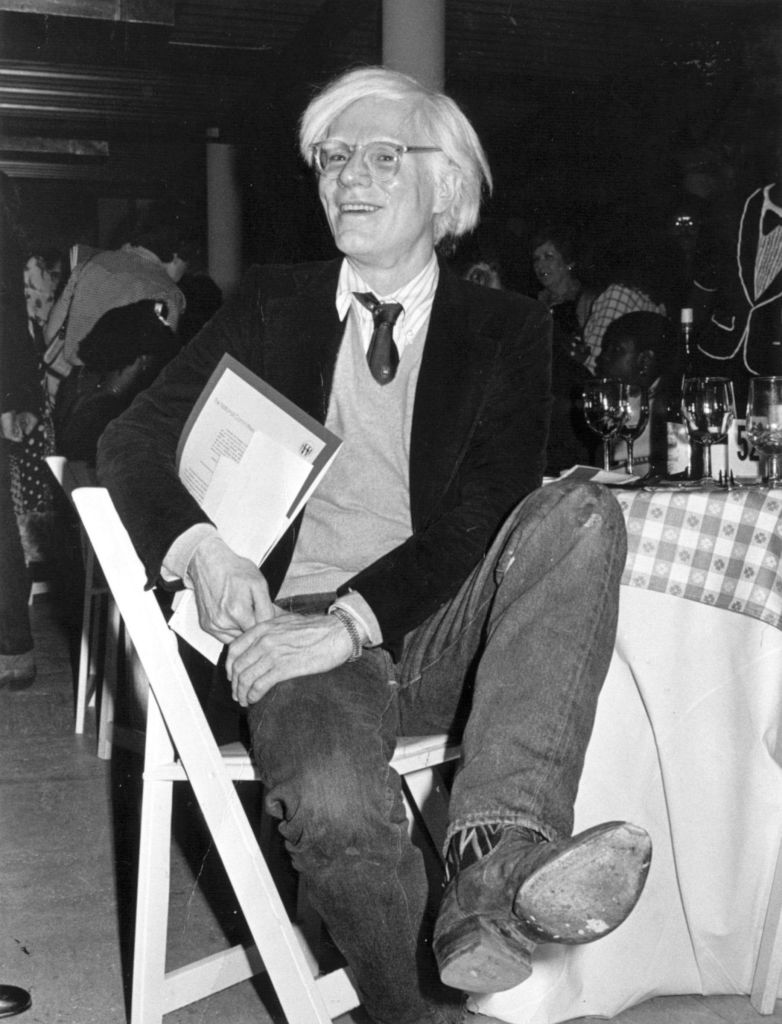 Artist Andy Warhol in cowboy boots at fundraiser, 1979