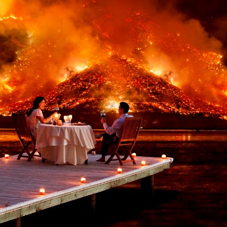 couple enjoys a romantic dinner as an apocalyptic hell scape blazes in the distance