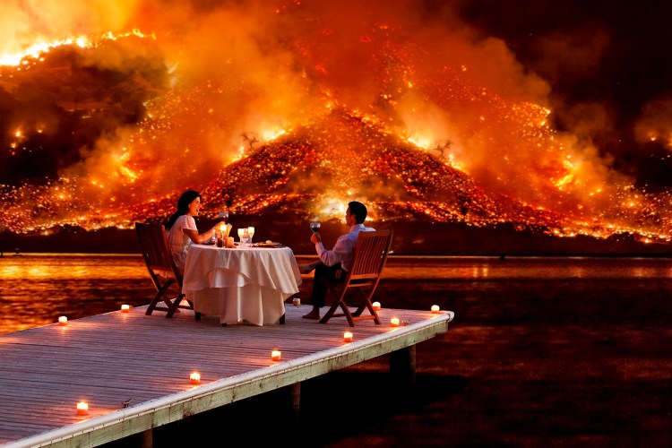 couple enjoys a romantic dinner as an apocalyptic hell scape blazes in the distance