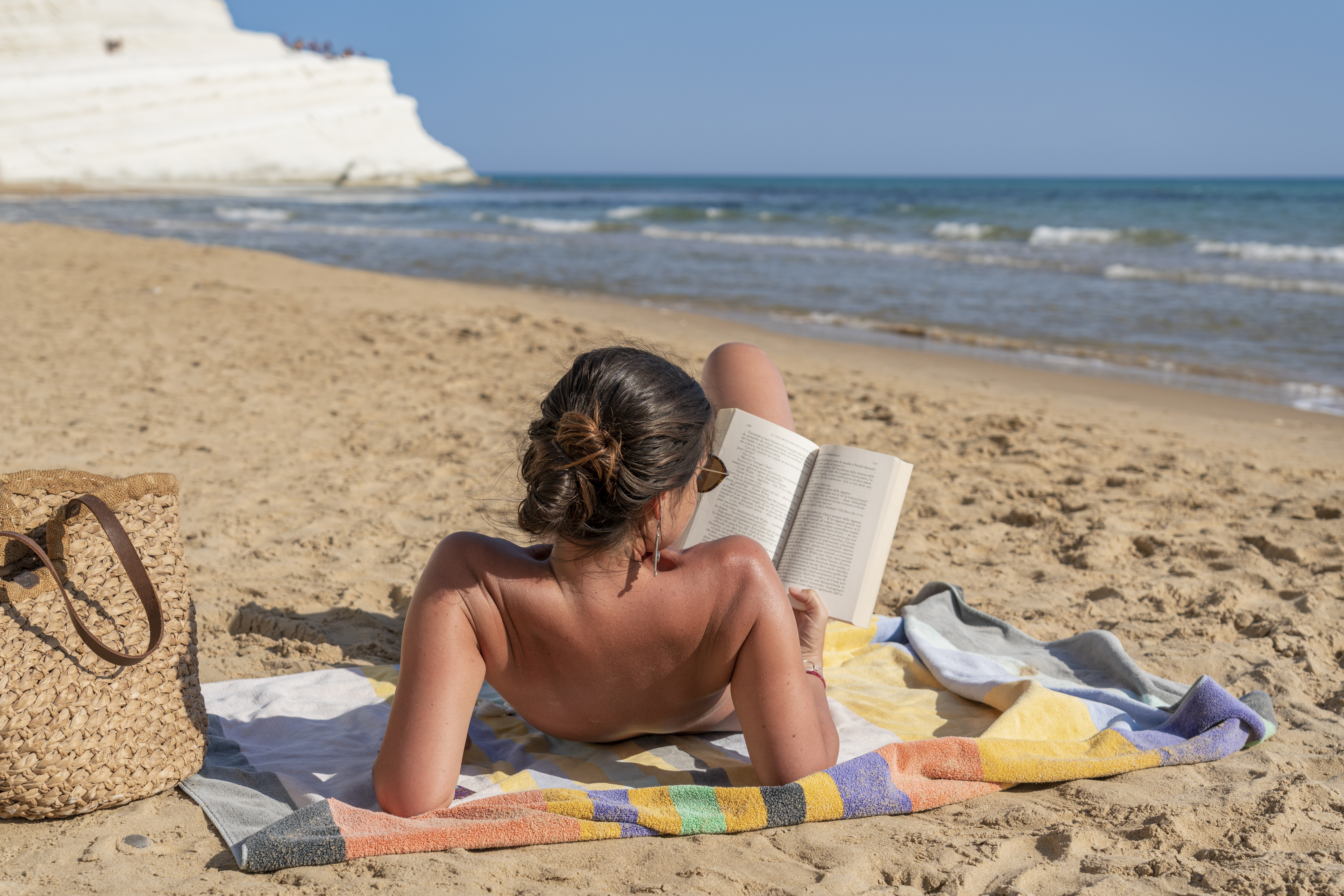 woman reading while sunbathing
