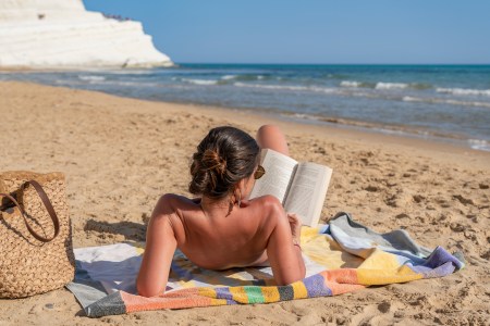 woman reading while sunbathing