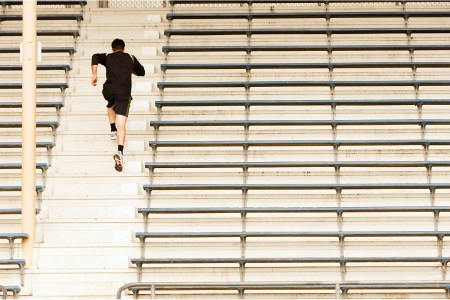 man running up bleachers
