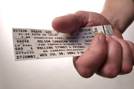 A hand holding a concert ticket