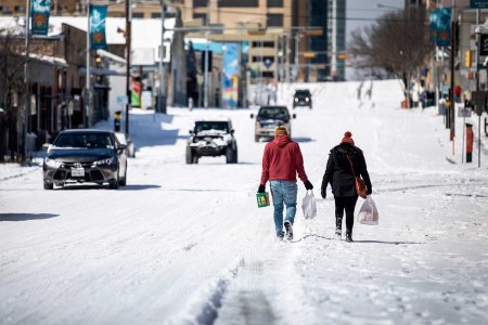 People carry groceries from a local gas station on February 15, 2021 in Austin, Texas. 