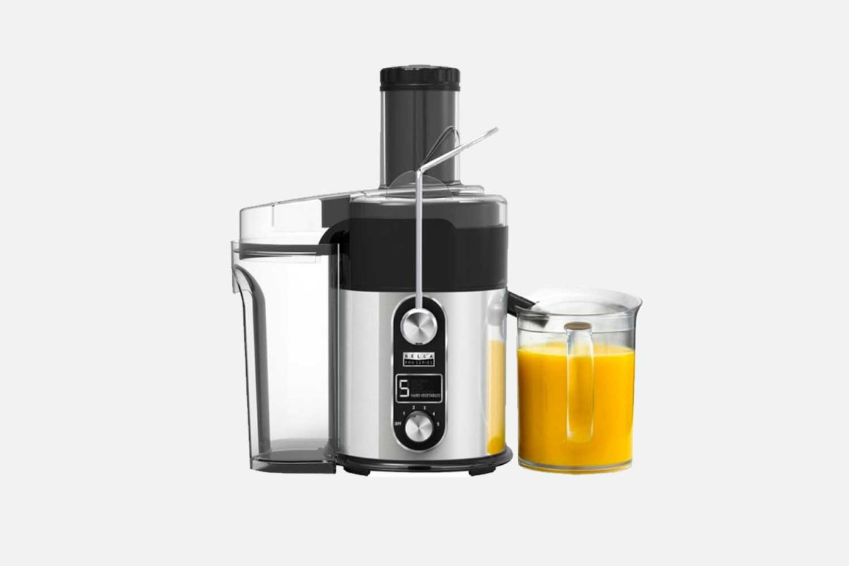 The Bella Pro Series Centrifugal Juice Extractor with orange juice on a grey background