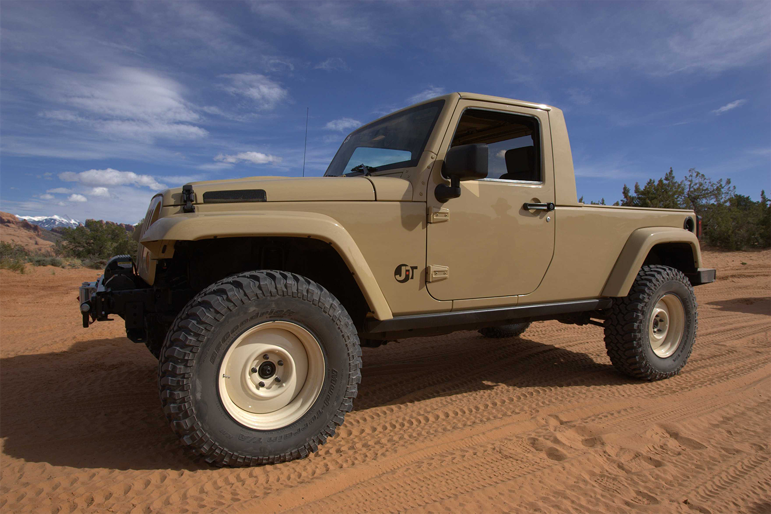 A beige two-door Jeep Wrangler truck in the desert at the Easter Jeep Safari