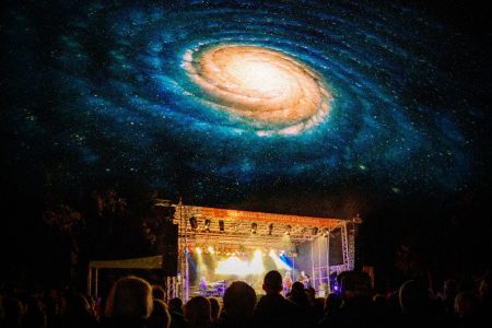 A psychedelic night sky over a music festival