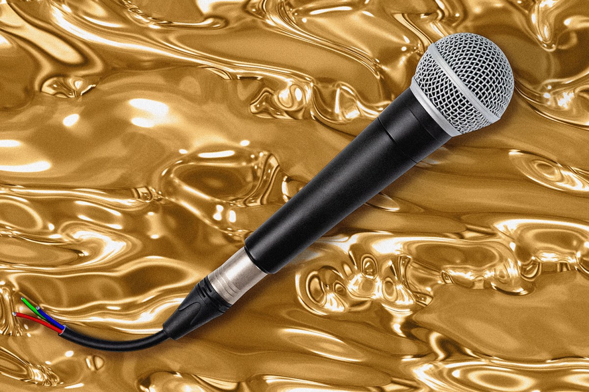 An unplugged microphone sits in front of a gold background