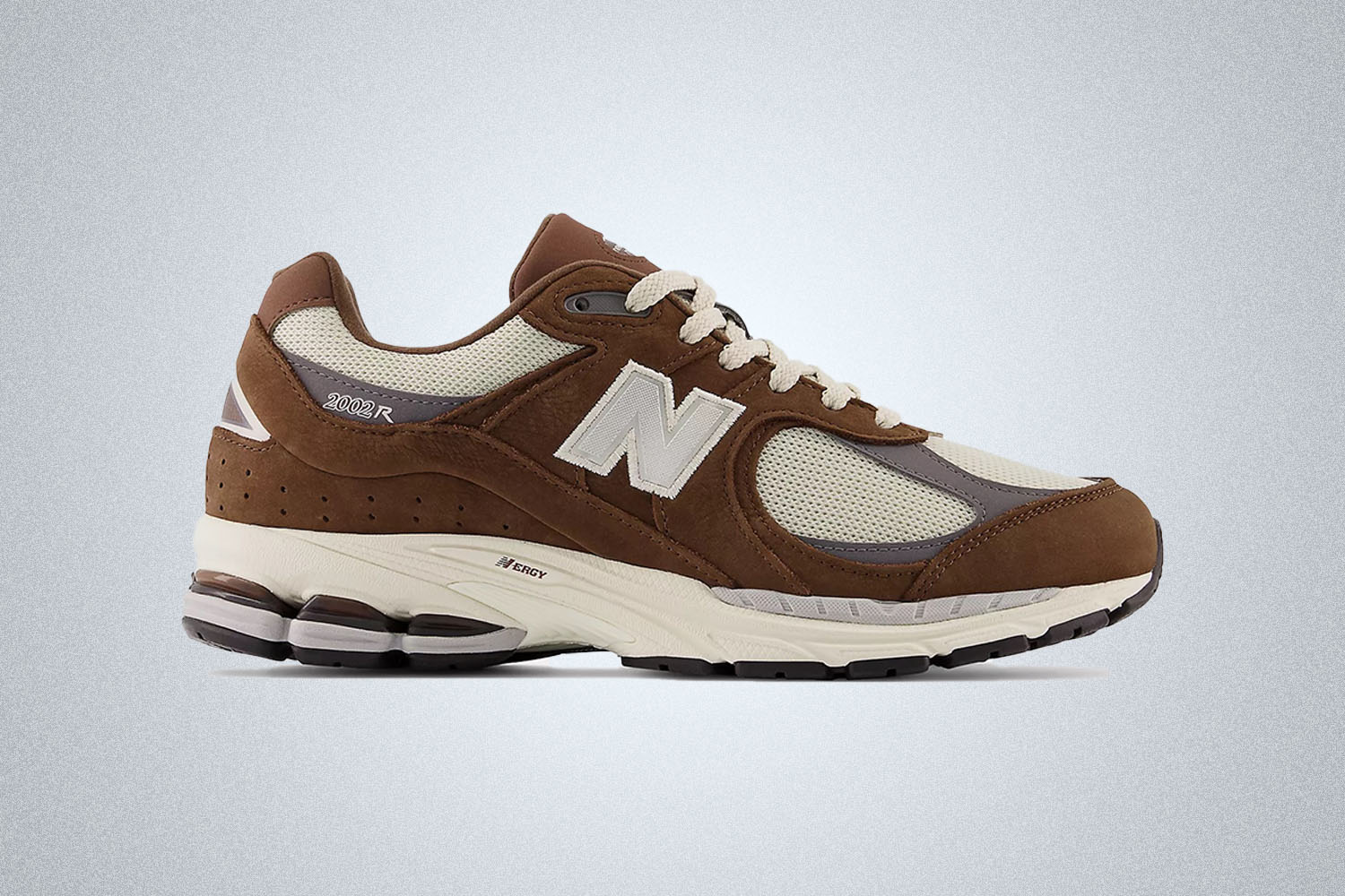 a pair of brown New Balance 2002R sneakers on a grey background