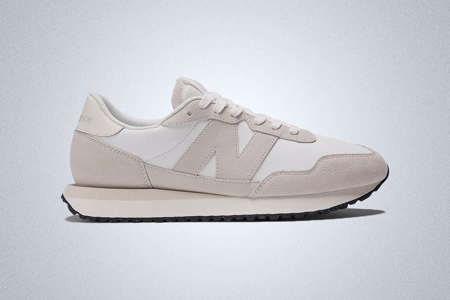 a pair of cream New Balance 237 on a grey background