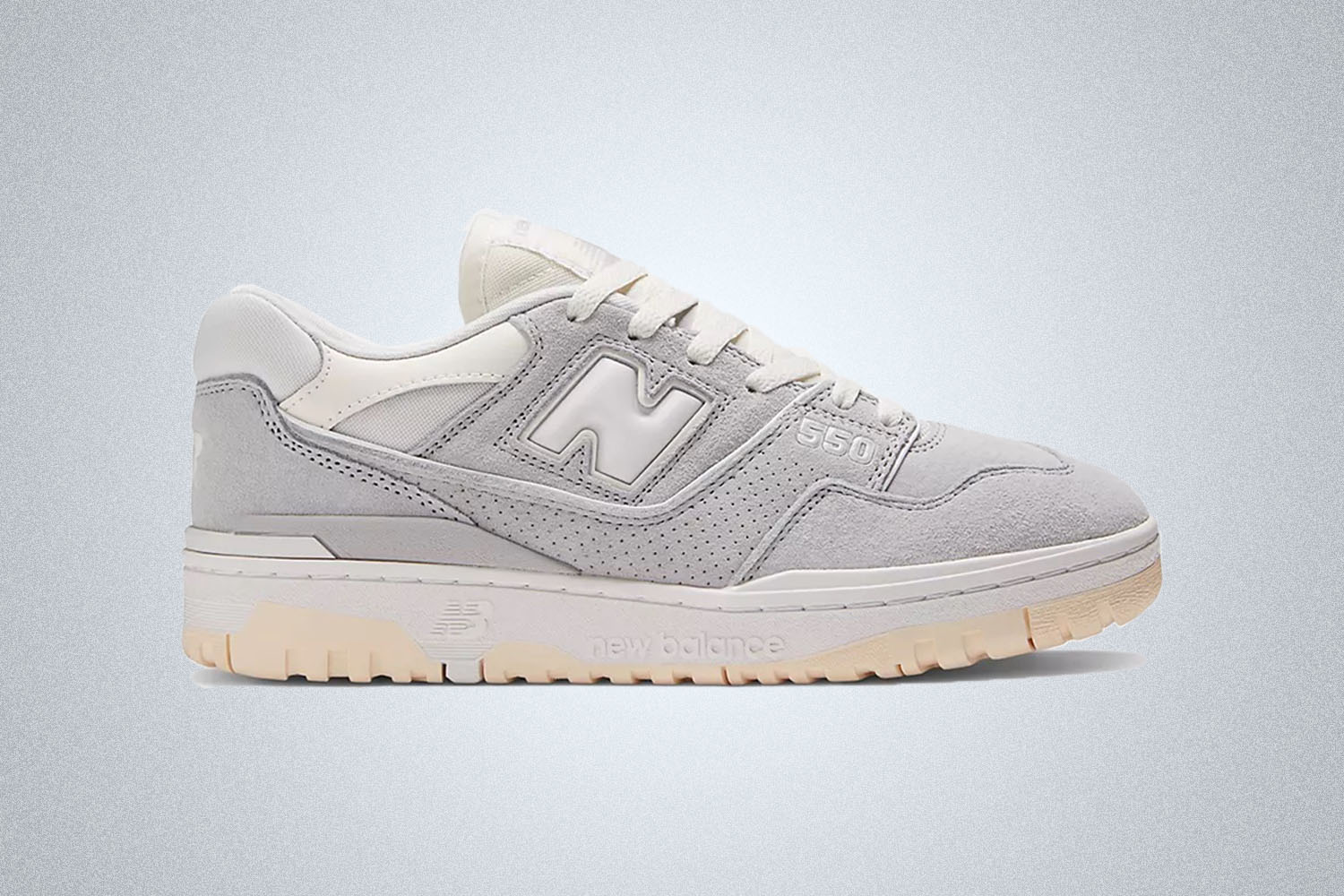 a pair of silver New Balance 550 on a grey background