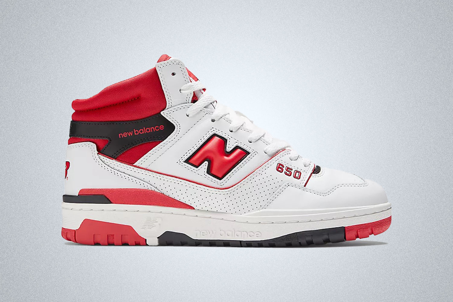 a pair of red and white NB basketball shoes on a grey background