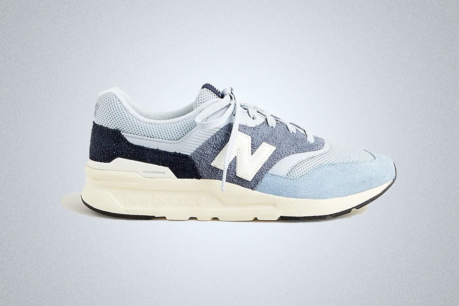 a blue NB 997 sneaker on a grey background