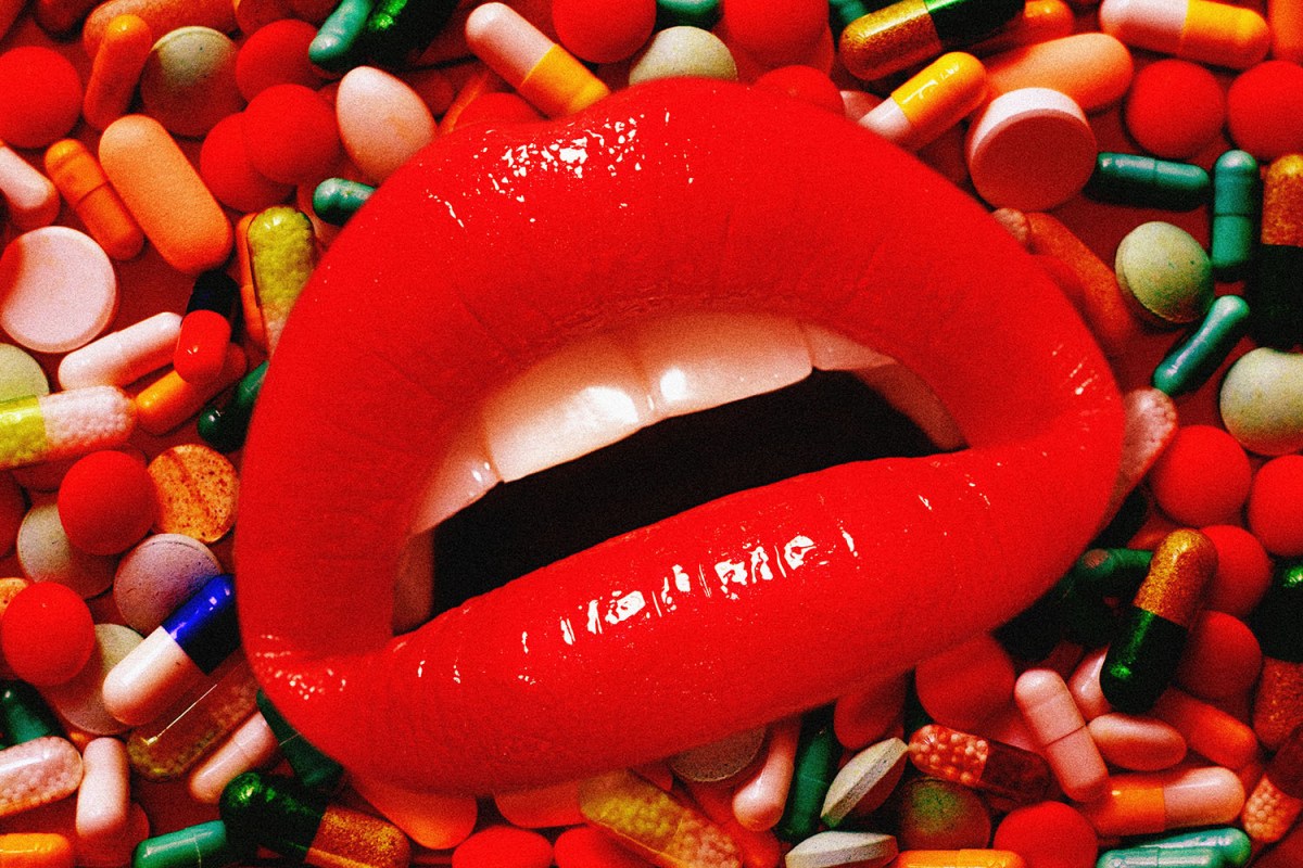 A disembodied mouth on a background of scattered pills