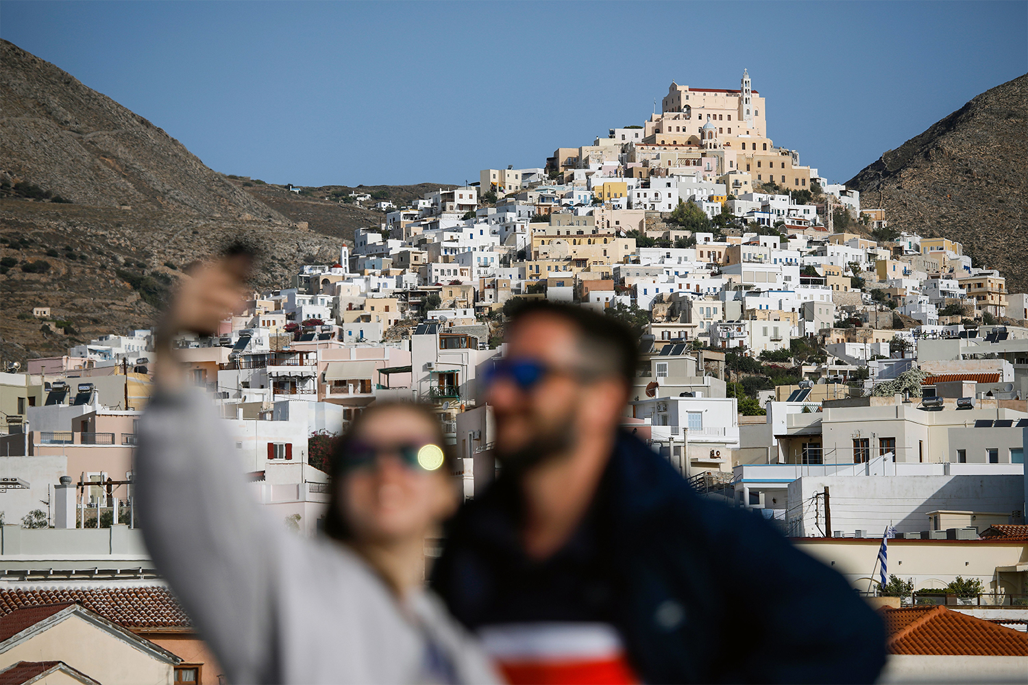 Tourists pose for a selfie in front if Syros Island