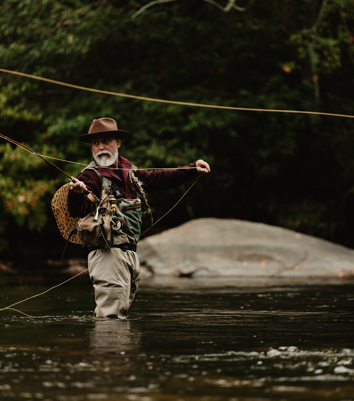 Bamboo fly rod craftsman Bill Oyster fishing in a river with the water up to his knees