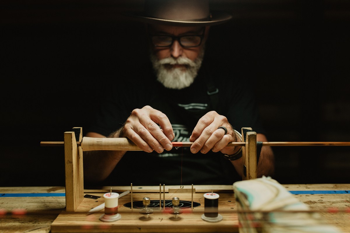 Bill Oyster wrapping a bamboo fly fishing rod on a table