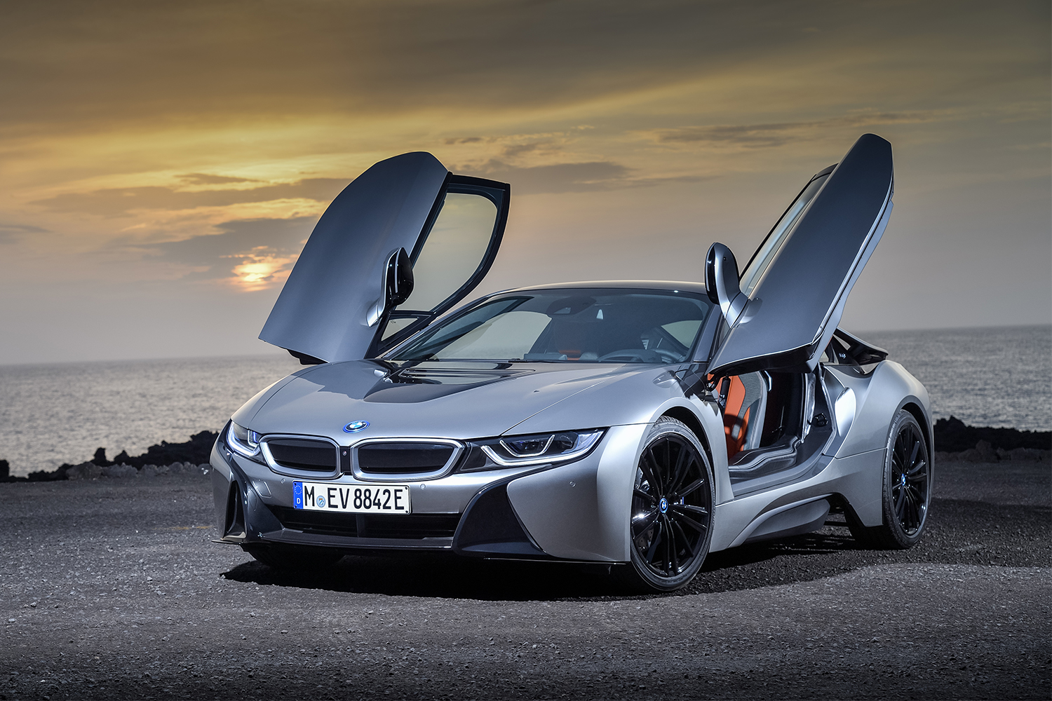A BMW i8 Coupe at dusk with its winged doors open