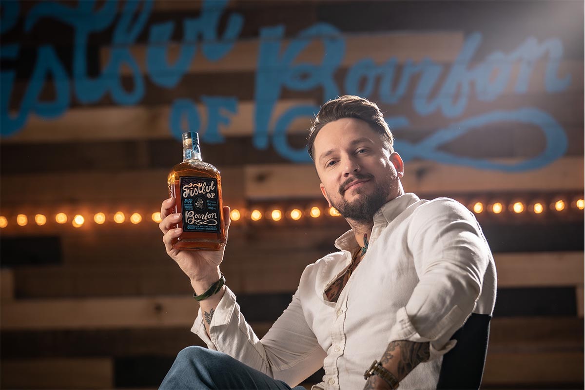 Fistful of Bourbon brand ambassador Anthony Bohlinger with a bottle of his brand's whiskey