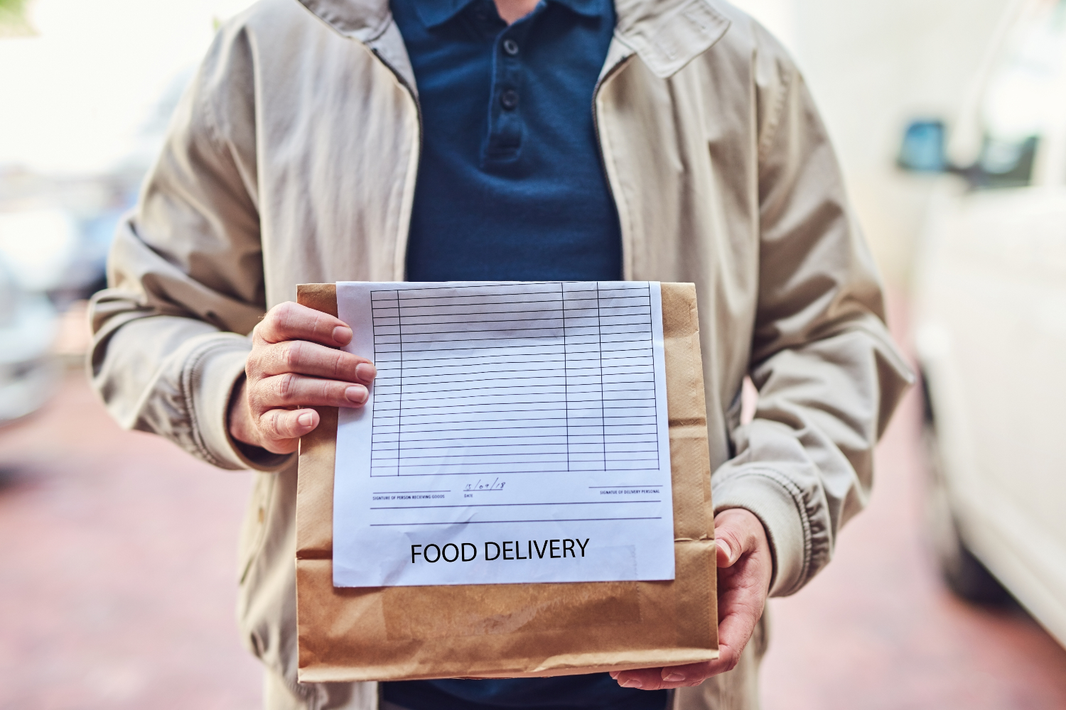 Food delivery man holding paper bag