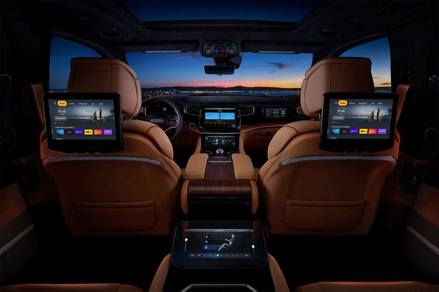 The interior of the 2022 Jeep Grand Wagoneer SUV shot from the second row, showing TV screens with Amazon Fire TV for Auto