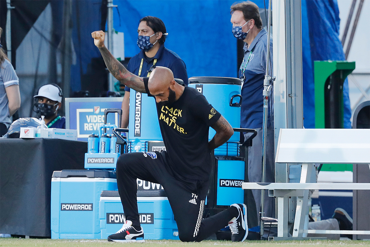 Thierry Henry, then head coach of the Montreal Impact, takes a knee at a match in July 2020