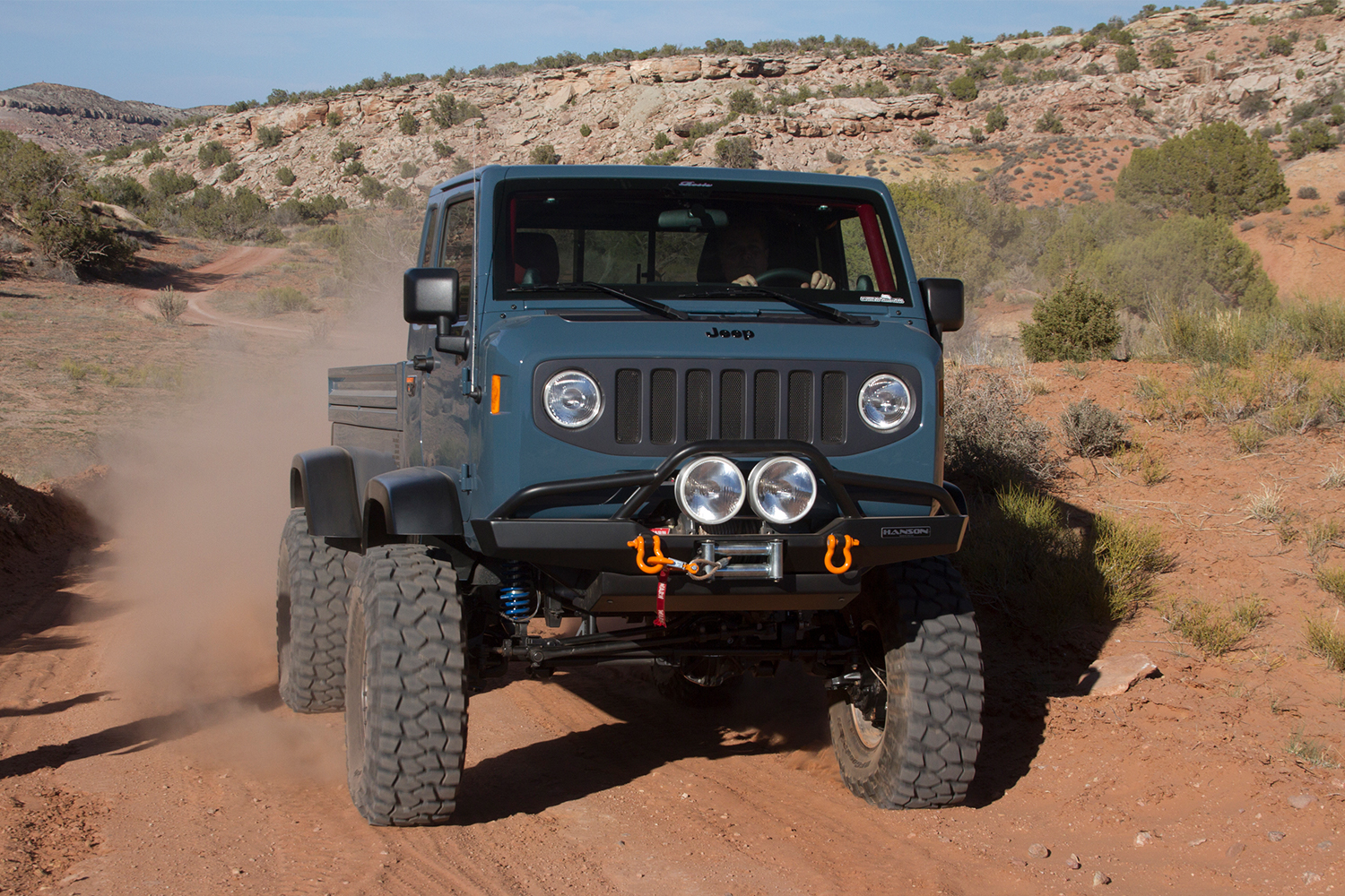 The Jeep Mighty FC cab-over-engine pickup truck driving in Moab