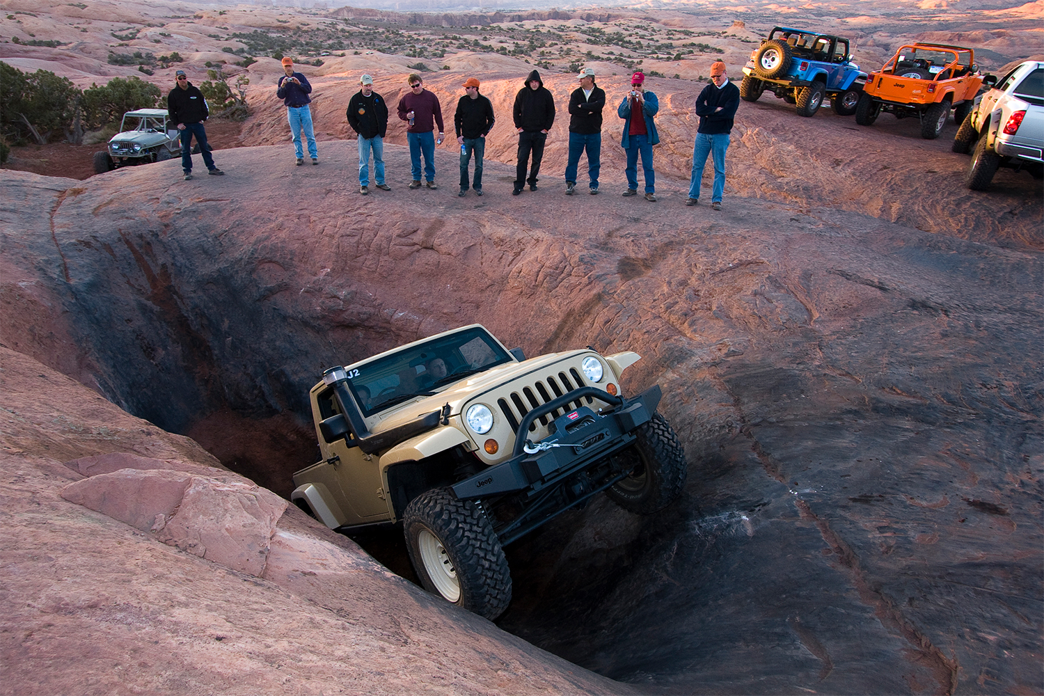 A beige Jeep Wrangler JT truck navigating an obstacle in Moah