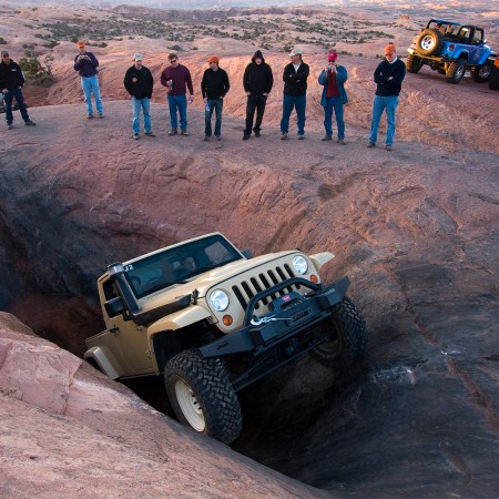 A beige Jeep Wrangler JT truck navigating an obstacle in Moah