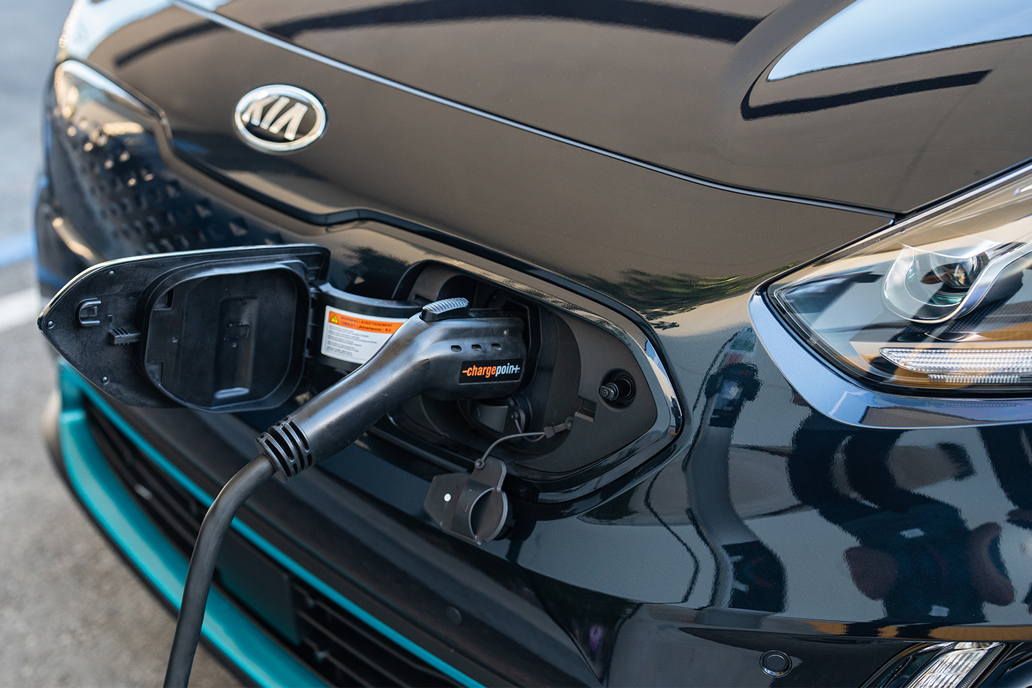A ChargePoint electric car charger plugged into the front of the Kia Niro EV crossover