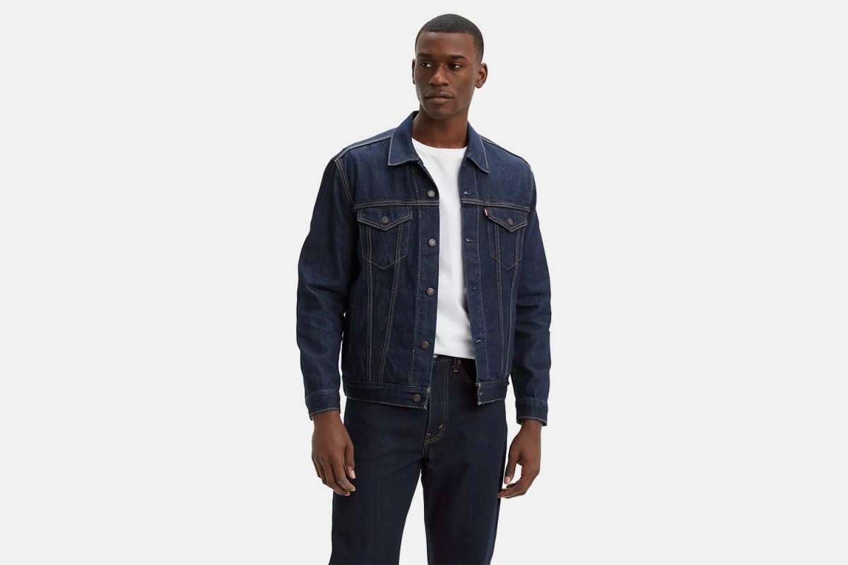 A man wearing Levi's Dark Wash Trucker Jacket and Jeans