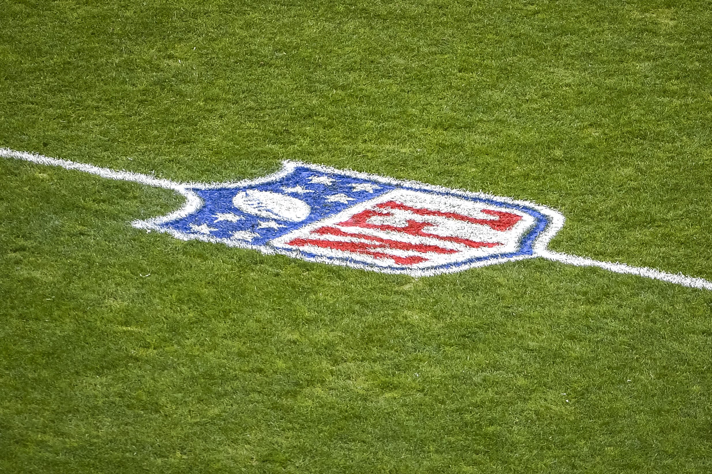 The NFL logo on the field.