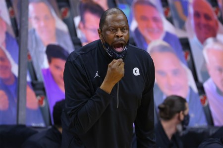 Georgetown Hoyas head coach Patrick Ewing pulling down his mask to yell at players