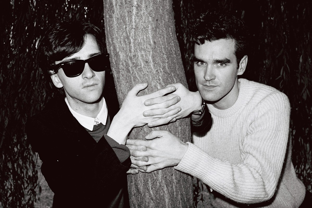 Johnny Marr (left) and Morrissey from The Smiths posed with their arms around a tree trunk in London in 1983.